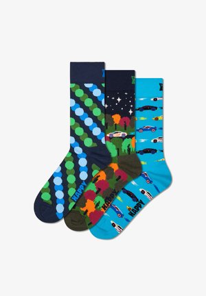 Drei Paare Socken: 1. Marineblau und grün mit Punkten. 2. Schwarz mit Bäumen und Autos. 3. Blau mit Rennwagen auf einem hellblauen Hintergrund.