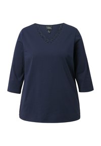 Navy sininen naisten paita, jossa on kolmanneksin hihat ja V-pääntie, sisältä scallop-lace-yksityiskohta.