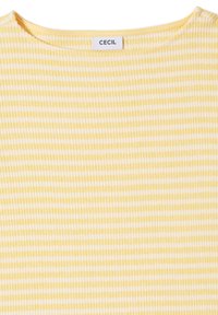 Chemise jaune clair côtelée avec des rayures blanches, dotée d'un col rond et d'une étiquette indiquant "CECI". Texture douce, design décontracté.