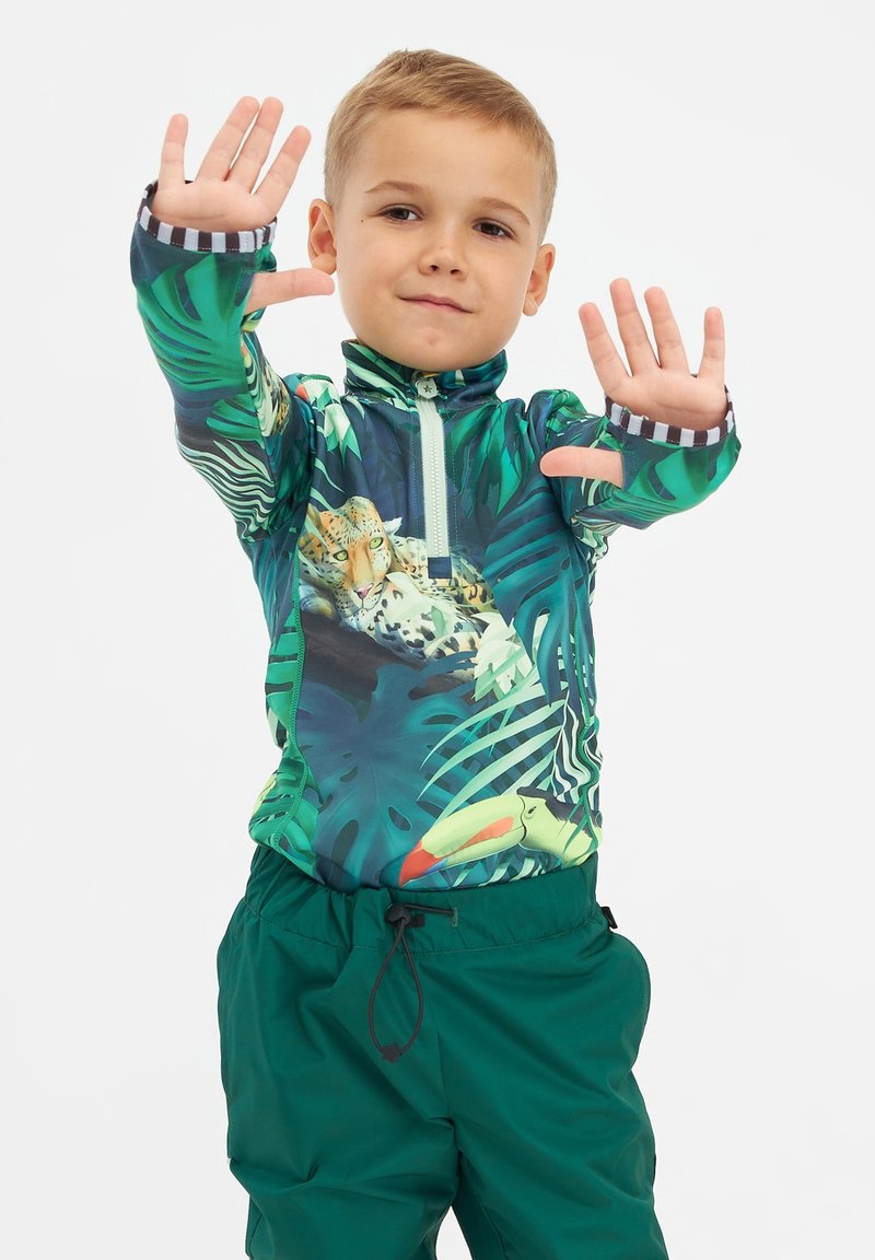 Langærmet rashguard med et grønt bladmønster og en jaguarillustration. Sammen med elastiske grønne badeshorts og lynlås foran.