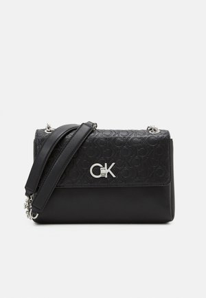 Sac à bandoulière en cuir noir avec motif de logo embossé, ferrures argentées et une sangle ajustable. Forme rectangulaire compacte avec texture lisse.