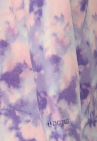 Fleece stof i lilla med pastelfarvet rosa sprøjt; har et subtilt zigzag-logo i det nederste højre hjørne. Blød, struktureret overflade.