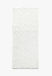 Vitt spetsmaterial med ett strukturerat blommönster. Den övre delen har en solid väv, som övergår till en detaljerad blommönster nedanför.