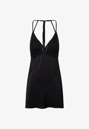 Crna mini haljina s dubokim izrezom, tankim pletenim naramenicama, središnjim okruglim zlatnim akcentom i glatkim satenskim završetkom.