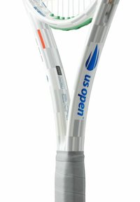 Raqueta de tenis con un marco blanco, detalles en verde y un agarre gris. Presenta la marca "US Open" y un acabado decorativo en el marco.