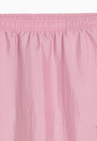 Prenda con cinturilla elástica rosa, hecha de un tejido ligero, con una textura arrugada y un diseño fruncido en la parte superior.