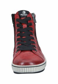 Baskets montantes en cuir rouge avec lacets noirs, fermeture éclair sur le côté et semelle en caoutchouc texturé. Présente un logo sur la languette et des surpiqûres contrastantes.