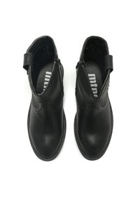 Botas de cuero negro hasta el tobillo con cremalleras laterales, puntas redondeadas y suelas texturizadas. Presentan una pestaña en la parte trasera para facilitar el calzado y un acabado suave.