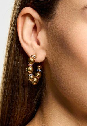 Pendientes de aro de oro con perlas redondeadas, acentuados con detalles en rosa y azul, que muestran una textura suave y brillante.