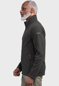 Dunkelgraue Fleecejacke mit hohem Kragen, Reißverschlusstaschen und kontrastierenden Nähten. Weiche Textur und ergonomische Passform für Komfort.
