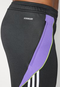 Zwarte sportshorts met een paarse en groene zijpaneel. Bevat Aeroready-logo, textuurstof en contrasterende witte strepen.