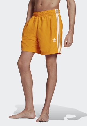 Costumi da bagno arancioni da uomo realizzati in un tessuto leggero, con vita elastica, tasche laterali e dettagli a righe bianche.