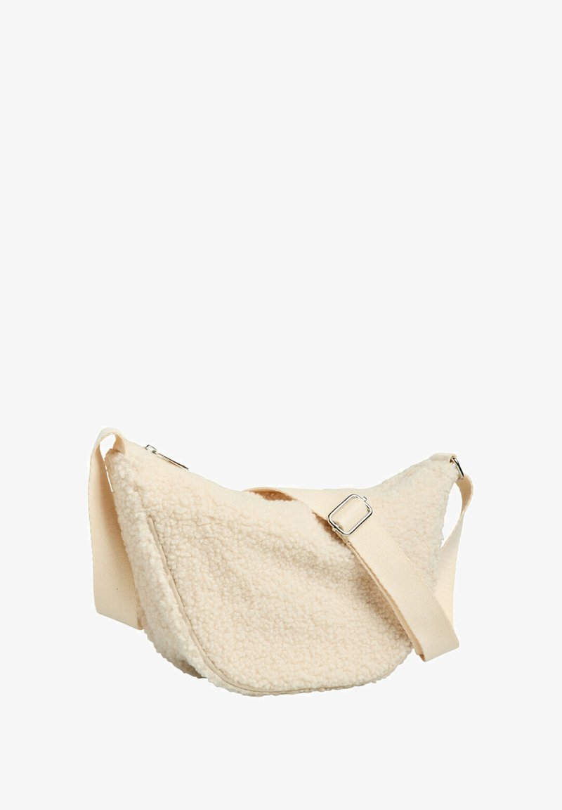 Bolso de piel sintética tipo borrego en color crema, con forma curva, correa ajustable de tela y un forro interior suave. Cuenta con detalles de herrajes metálicos.