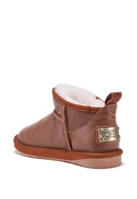 Stivaletto in pelle marrone con fodera in shearling, punta rotonda, dettagli cuciti e placca metallica del marchio sul lato, dotato di suola in gomma.