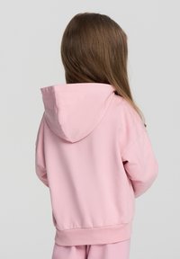 Felpa con cappuccio rosa dalla vestibilità rilassata, con tasca a marsupio e polsini a costine. Tessuto morbido in misto cotone con una texture liscia.