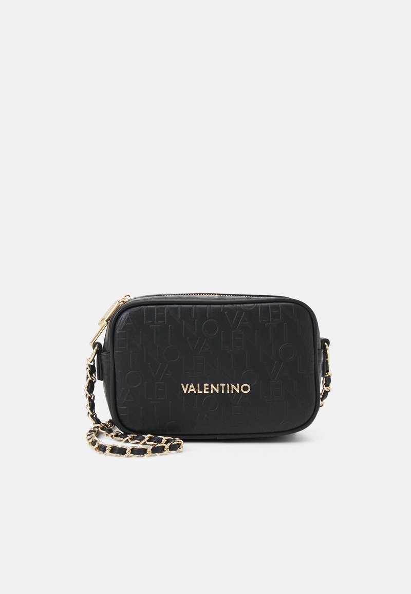 Black leather crossbody bag with an embossed logo pattern, gold hardware, zip closure, and a chain strap. Compact rectangular shape.
