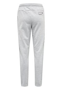Graue Sweatpants mit schmalem Schnitt, elastischem Bund, Seitentaschen und einem Etikett auf der Rückseite, hergestellt aus einem weichen, strukturierten Stoff.