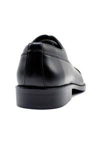 Chaussure en cuir noir, texture lisse, design arrondi, talon bas, détails de couture subtils et semelle solide noire.