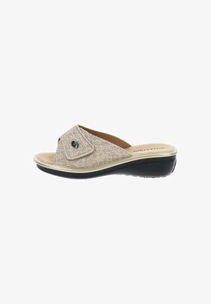 Sandalia beige abierta en la puntera, tipo slip-on con correa ajustable, plantilla acolchada y suela negra diseñada para comodidad y uso informal.