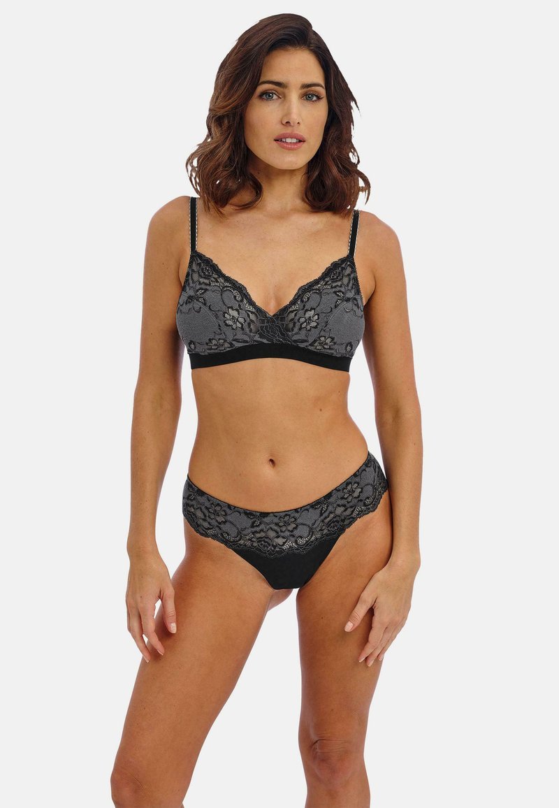 Mustasilmäinen ja harmaa pitsinen bralette, jossa on kukkakuosi ja säädettävät hihnat, yhdistettynä yhteensopiviin pitsireunaisiin hipster-pikkareihin. Tasainen pinta.