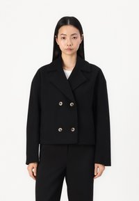 Black cropped blazer with a double-breasted front, broad collar, and silver-tone buttons; made of a thick fabric for structured shape.