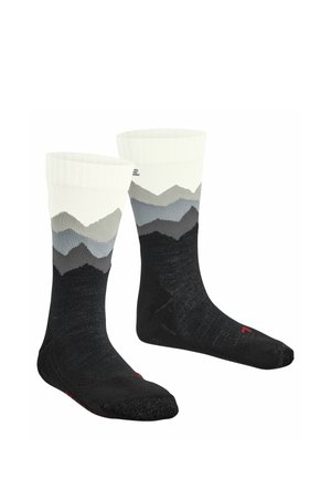 Paar schwarze Socken mit weißen Bündchen und einem grauen und schwarzen Bergmuster um die Waden.