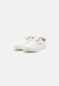 White canvas sneakers with round toe, lace-up front, brown accents on the ankle, and white rubber sole. Smooth texture with minimal detailing.