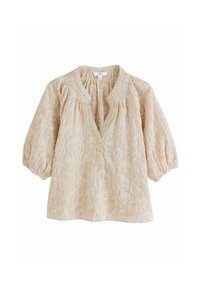 Blouse beige clair avec un motif floral, décolleté en V, patte de boutonnage et manches bouffantes. Tissu texturé avec une délicate broderie.