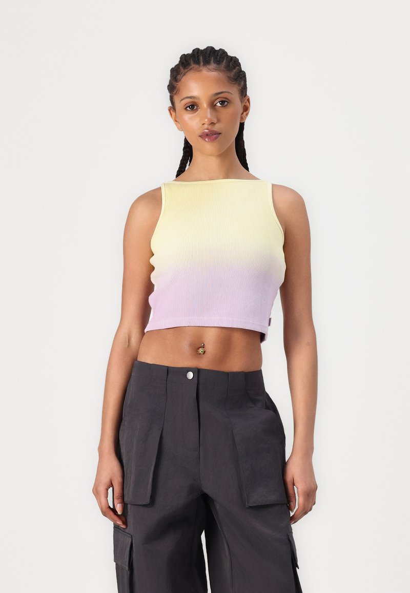 Sleeveless cropped top featuring a ribbed texture with a gradient from yellow to lavender; paired with dark cargo pants.