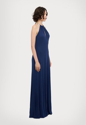 Abito lungo smanicato di un elegante blu navy, con un unico foro frontale a chiave e un tessuto leggero e fluido. Il design lungo si estende fino al pavimento.