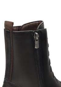 Botină neagră din piele, cu fermoar pe lateral, având un finisaj texturat și accente elastice maro în partea de sus pentru un plus de confort la purtare.