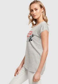 Gray cotton t-shirt with short sleeves, featuring red text "We are all in the same boat" and graphic designs. Soft texture, relaxed fit.