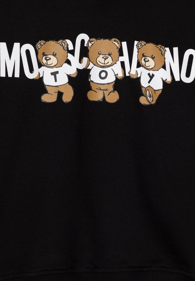 Felpa nera con tre illustrazioni di orsetti caricaturali dai colori marrone e bianco, abbinata a un testo audace che dice "MOSCHINO TOY."