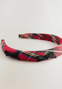 Rotes Karostoff-Haarband mit schwarzen Satinschleifen auf weißem Hintergrund.