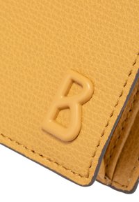 Žlutá texturovaná peněženka s vyvýšeným béžovým logem "B", se šedým prošíváním podél okrajů pro zvýraznění detailu.