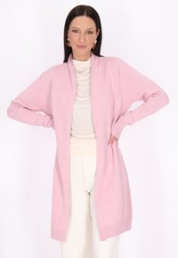 Lång, öppen cardigan i mjuk rosa stickning, med ribbade ärmslut och ett subtilt strukturerat mönster genom hela plagget.