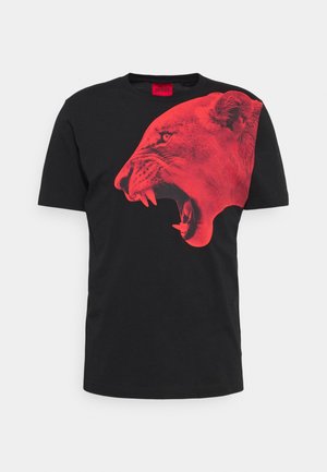 Czarny T-shirt z krótkim rękawem z dużą czerwoną grafiką ryczącej głowy lwicy na przedniej prawej stronie oraz czerwoną metką marki na kołnierzu.