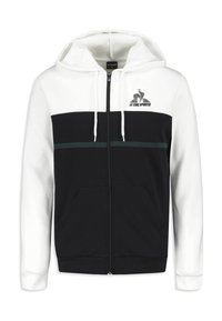 Felpa con cappuccio zip in bianco e nero. Presenta una parte inferiore completamente nera, una parte superiore bianca a contrasto, una striscia verde di accento e tasche a marsupio.