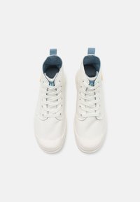 Zapatillas deportivas altas blancas de lona, con puntera redondeada, costuras a tono, acentos en azul claro y un lazo en el talón.