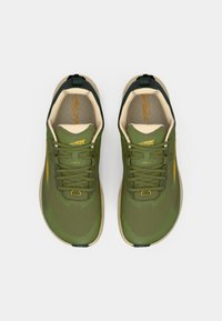 Green athletic shoes with mesh upper, reinforced toe, and yellow accents. Light beige midsole and dark green heel counter.