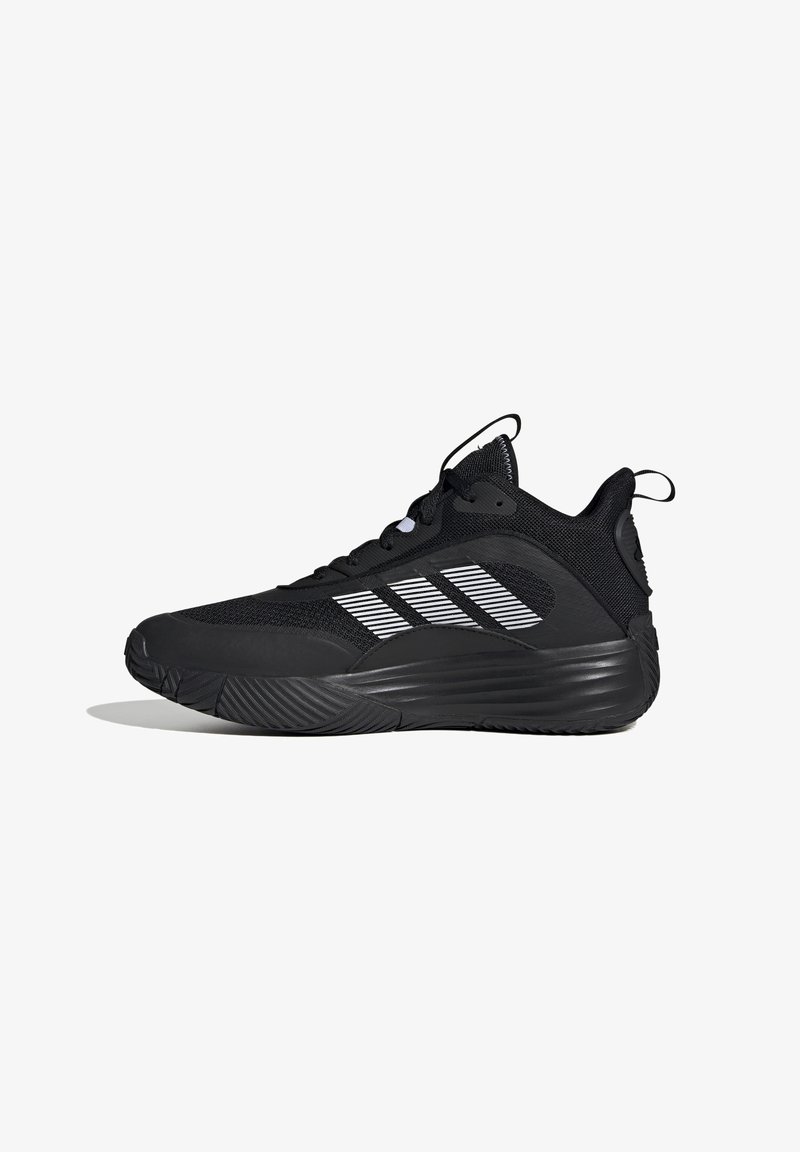 Baskets de sport noires avec une tige en maille et une semelle en caoutchouc. Présentent trois bandes blanches et des accents texturés sur le talon et l'orteil.