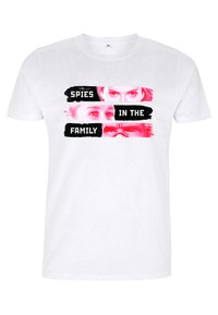 Camiseta de algodón blanca con un estampado gráfico de rostros y el texto "ESPÍAS EN LA FAMILIA" en negro y rosa. Mangas cortas, diseño de cuello redondo.