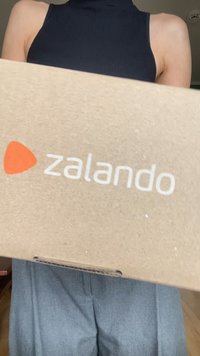 Brown cardboard box with a white "zalando" logo and orange accent. The box has a simple rectangular design with no visible patterns.