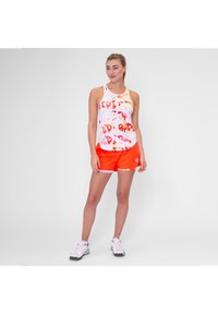Weißes Tanktop mit rotem und orangefarbenem abstraktem Print, kombiniert mit leuchtend orangefarbenen Shorts. Das Material wirkt leicht; enthält ein Logodetail.