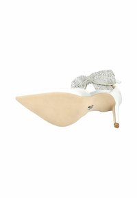 White pointed-toe high heel shoe with a stiletto heel and a silver sequined bow detail on the ankle strap. Textured sole is nude.