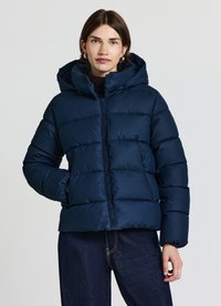 Giubbotto imbottito blu navy con cappuccio, caratterizzato da una chiusura frontale con zip, design trapuntato e polsini elasticizzati. Il materiale sembra liscio e termoisolante.