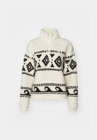 Fleece pullover in crèmekleur met zwarte tribale patronen. Voorzien van een halve rits kraag en lange mouwen. Zachte textuur en een relaxte pasvorm.