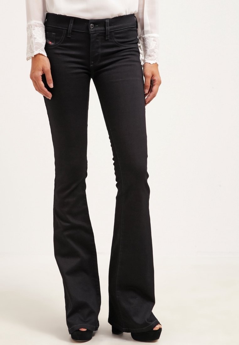 Pantalones vaqueros de tiro alto, de corte acampanado y color negro, confeccionados en denim, con bolsillos frontales, cremallera y detalles de costura sutiles.