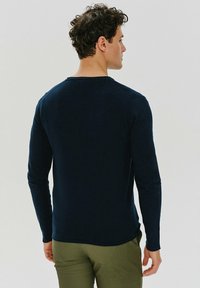 Granatowa koszula z długim rękawem, wykonana z gładkiego, elastycznego materiału, z okrągłym dekoltem, charakteryzująca się dopasowanym krojem i subtelnymi detalami szycia.