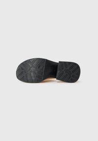 Tălpic din cauciuc negru, cu un model texturat pentru aderență, având un toc plat și un design fără cusături pentru stabilitate și suport.